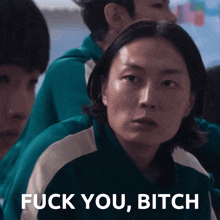 a man in a green jacket says " fuck you bitch " in front of a group of people