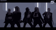 a group of women are dancing in front of a sign that says ' the k ' on it