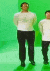 a blurry picture of two people standing in front of a green screen