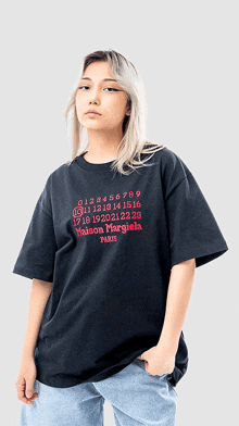 a woman wearing a black t-shirt that says maison margiela paris