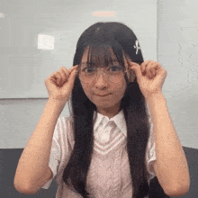 a young girl wearing glasses and a vest is making a face .