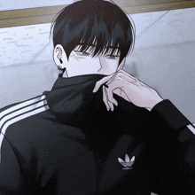 a man wearing a black adidas jacket is covering his face