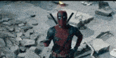 a man in a deadpool costume is standing in the middle of a pile of rocks