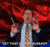 a man in a suit and tie is holding two syringes and says `` get that ozempi already '' .