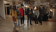 a group of people standing in a room with a sign on the wall that says ' a '