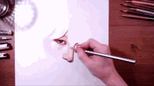 a person is drawing a woman 's face with a pencil on a wooden table