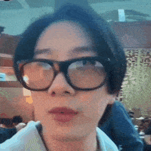 a man wearing glasses is looking at the camera