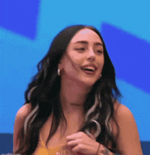 a woman with long hair and a tattoo on her arm is smiling and laughing .