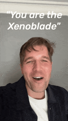 a man is smiling in front of a sign that says you are the xenoblade