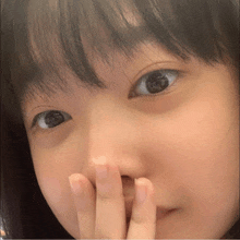 a close up of a person covering their nose with their hand