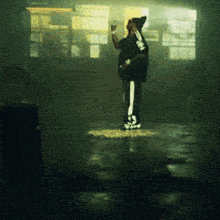 a person standing in a dark room holding a bottle