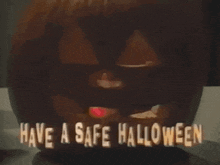 a pumpkin is sitting on a table with the words `` have a safe halloween '' above it .
