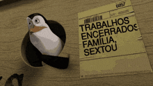 a penguin in a hole next to a piece of paper that says trabalhos encerrado familia sextou