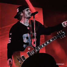 a man playing a guitar and singing into a microphone