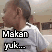 a young boy with a shaved head says makan yuk