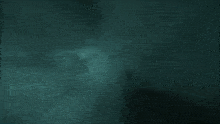 a person is holding a glowing object in their hand in a dark room