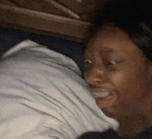 a close up of a person laying on a bed with a white pillow .