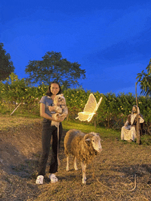 a woman holding a dog standing next to a sheep with a butterfly in the background