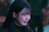 a close up of a woman 's face with tears coming out of her eyes