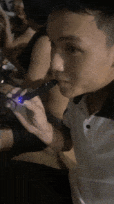 a man in a white shirt is holding a blue light