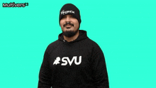 a man wearing a smu sweatshirt and a beanie is making a heart shape with his fingers