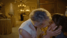 a woman is kissing another woman on the forehead