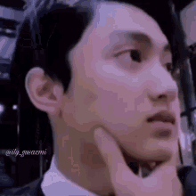a close up of a person 's face with a hand on their chin .