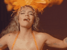 a woman is wearing a feathered headpiece and dancing