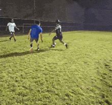 a man in a blue shirt is playing soccer with another man