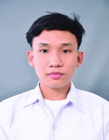 a young man in a white shirt is standing in front of a grey background .