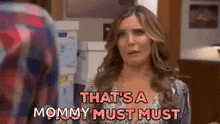 a woman is standing in a kitchen talking to a man and saying `` that 's a mommy must must '' .