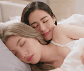 two women laying in bed with their eyes closed and a watermark that says lingoomgif39