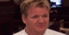 a close up of a man 's face in a white shirt .