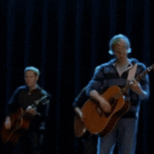a blurry picture of a group of people playing guitars on a stage