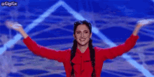 a woman is standing on a stage with her arms outstretched and smiling .