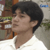a man sitting in front of a sign that says gma