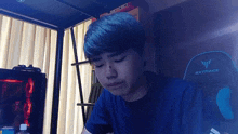 a young man is sitting in front of a gxtrace chair