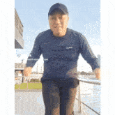 a man wearing a blue shirt with the letter l on it is standing on a boat