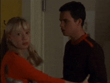 a man and a woman are standing next to each other in front of a door