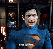 a man in a superman costume is saying eyes up here