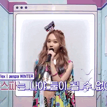 a woman is singing into a microphone while wearing a colorful dress .