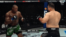 two men are fighting in a boxing ring and one of them is wearing green shorts that say abdel wahab