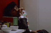 a man in a suit is smoking a cigarette while sitting at a table