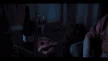 a person sitting in a dark room with a glass of wine