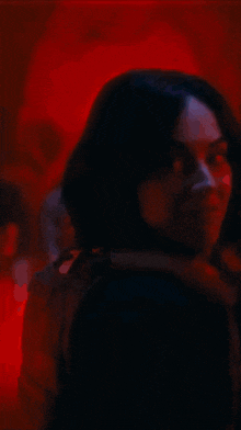 a close up of a woman 's face in the dark with red eyes