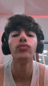 a young man wearing headphones is making a face