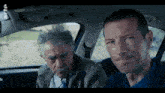 two men are sitting in a car with the letters rtl on the screen