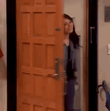 a woman is standing in front of a wooden door that has a lock on it .