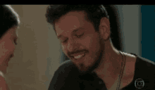 a man and a woman are smiling at each other .