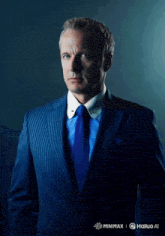 a man in a blue suit and tie is standing in front of a sign that says minimax